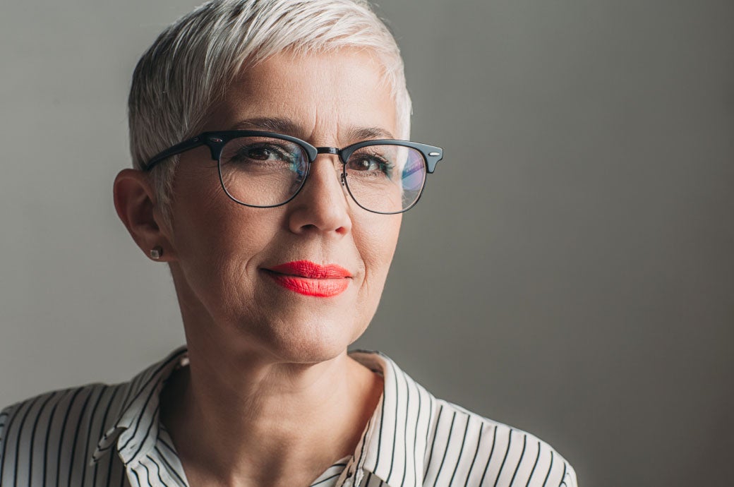 Headshot of professional looking woman with short, white hair and glasses